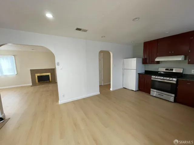 a view of kitchen with stainless steel appliances granite countertop a stove and a sink