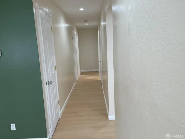 a view of a hallway with wooden floor