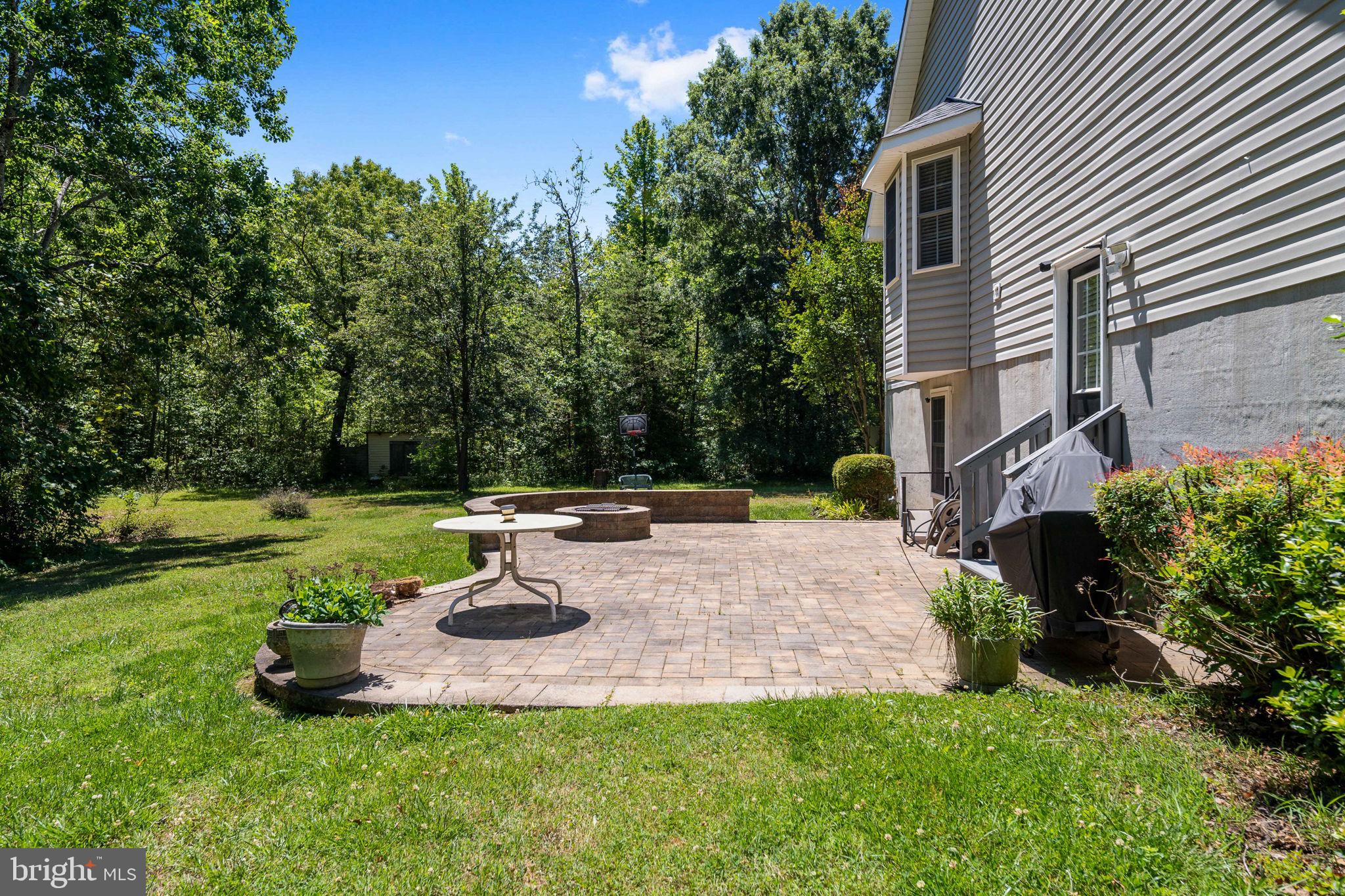 8009 Burrell Road Fredericksburg, VA 22407 - Photo 59 of 66 Serene patio retreat in lush greenery.