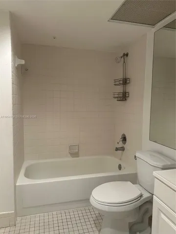 a bath room with a toilet a bath tub and a shower