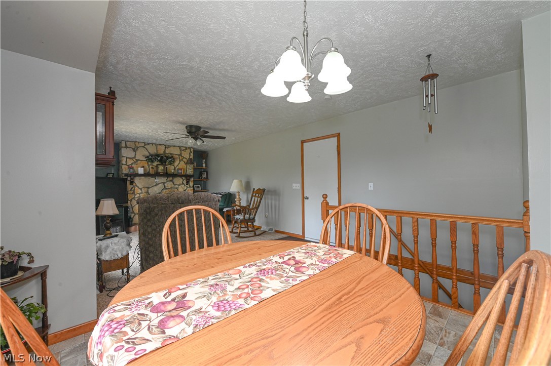 13425 Chardon-Windsor Road Chardon, OH 44024 - Photo 10 of 50 Tiled dining room with ceiling fan with notable chandelier and a textured ceiling