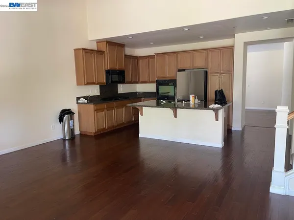 a kitchen with stainless steel appliances a refrigerator and wooden floor