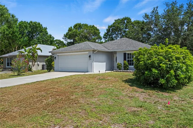 a view of a house with a yard and potted plants