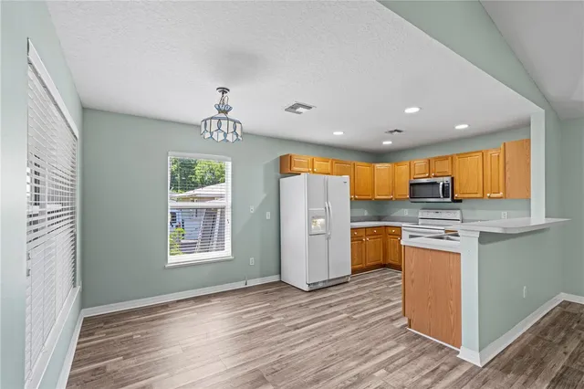 a view of a kitchen with a sink a refrigerator and window