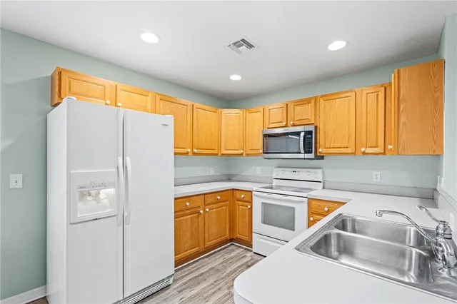 a kitchen with a sink a refrigerator and cabinets
