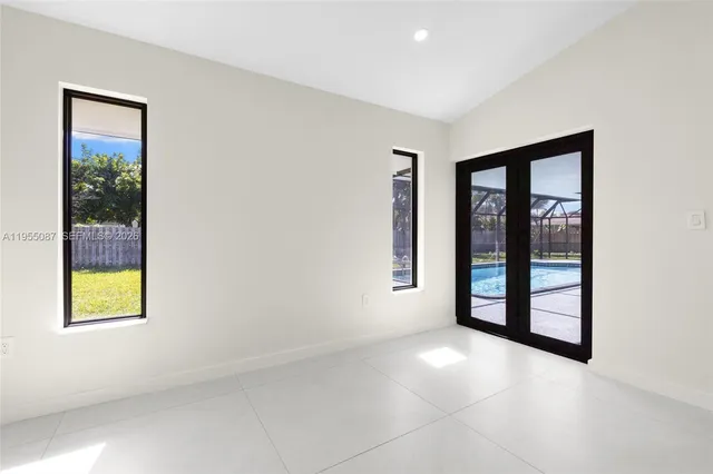 an empty room with windows and ceiling fan