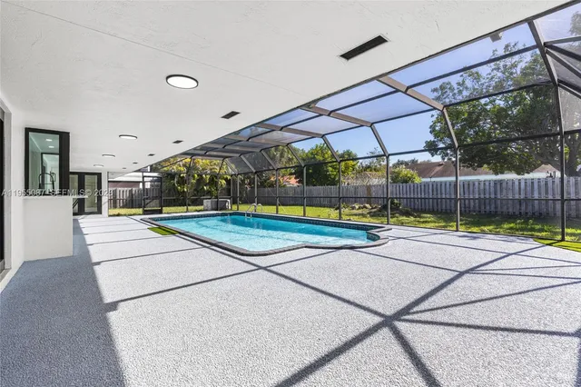 a view of a house with a big yard and large trees