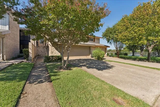 a front view of a house with a yard and trees