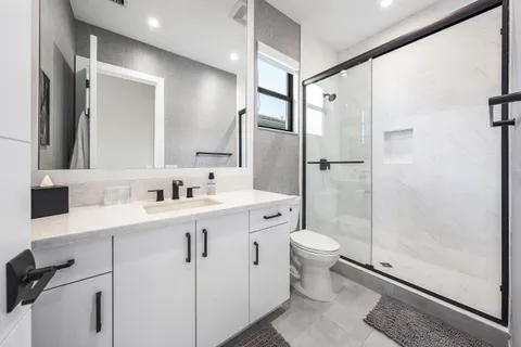 a bathroom with a double vanity sink toilet and shower