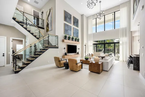 a living room with furniture a flat screen tv and a chandelier