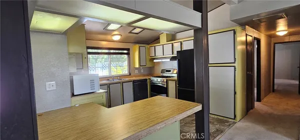 a view of kitchen with window and refrigerator