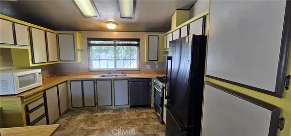 a kitchen with stainless steel appliances granite countertop a refrigerator a stove a sink and a refrigerator