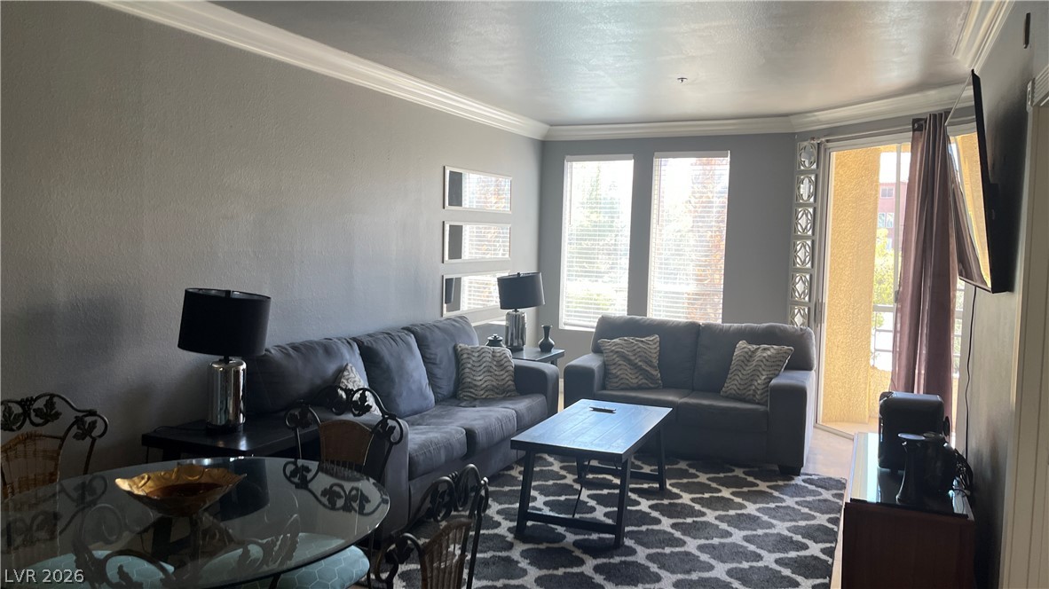 210 East Flamingo Road, Unit 205 Las Vegas, NV 89169 - Photo 9 of 17 The living area offers generous space for entertaining and relaxation, complemented by the elegant crown molding throughout.