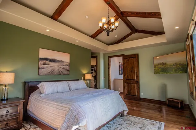 a bedroom with a large bed and a chandelier