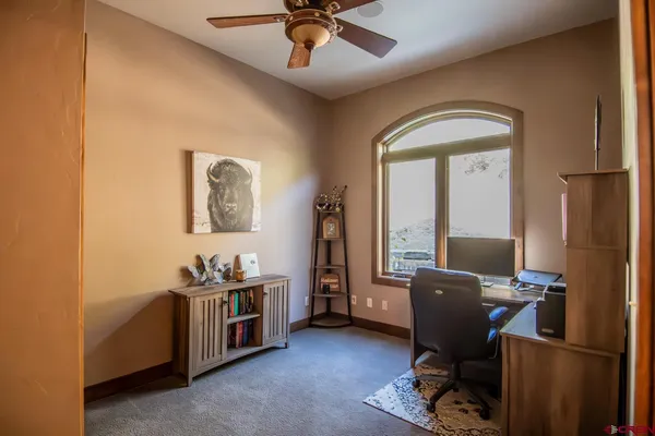 a view of a workspace with furniture and a window