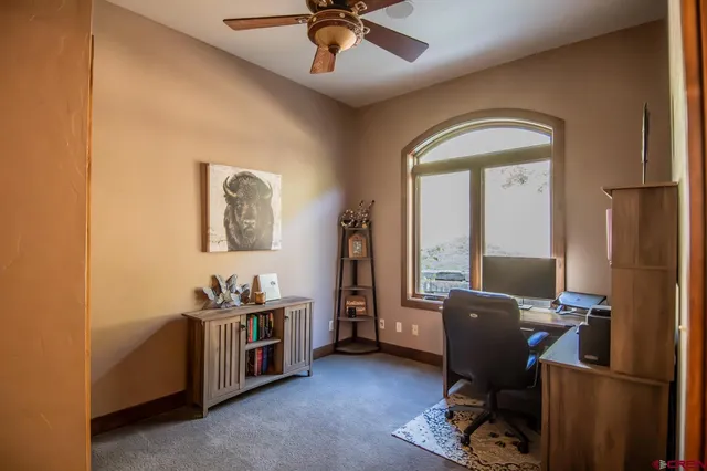 a view of a workspace with furniture and a window