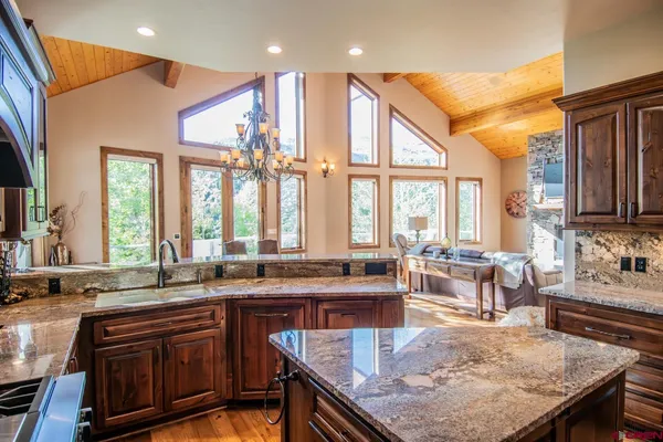 a kitchen with large windows and living room