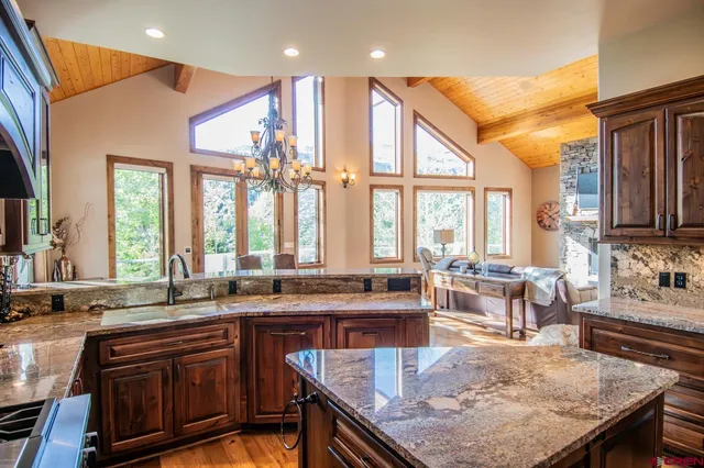a kitchen with large windows and living room