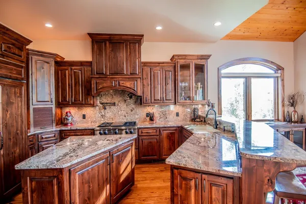 a kitchen with stainless steel appliances granite countertop wooden cabinets and a stove top oven