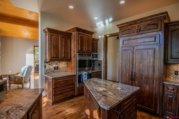 a kitchen that has a kitchen island wooden cabinets and stainless steel appliances