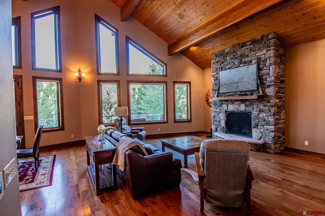a living room with furniture a fireplace and wooden floor