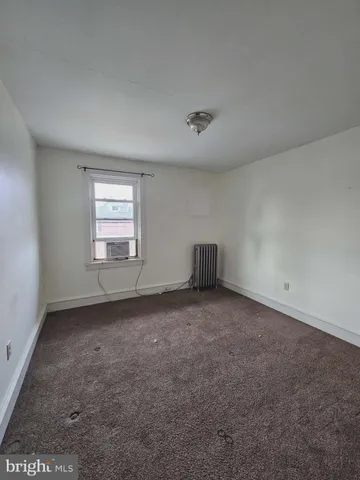 a view of empty room with window and ceiling fan