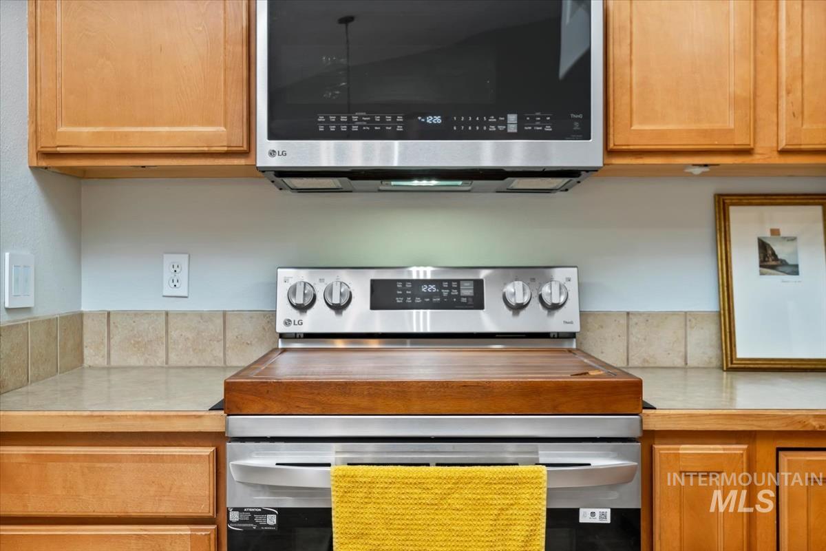 80 Cobblestone Court Middleton, ID 83644 - Photo 10 of 48 Stainless steel range with a built-in microwave oven, complemented by natural wood cabinetry