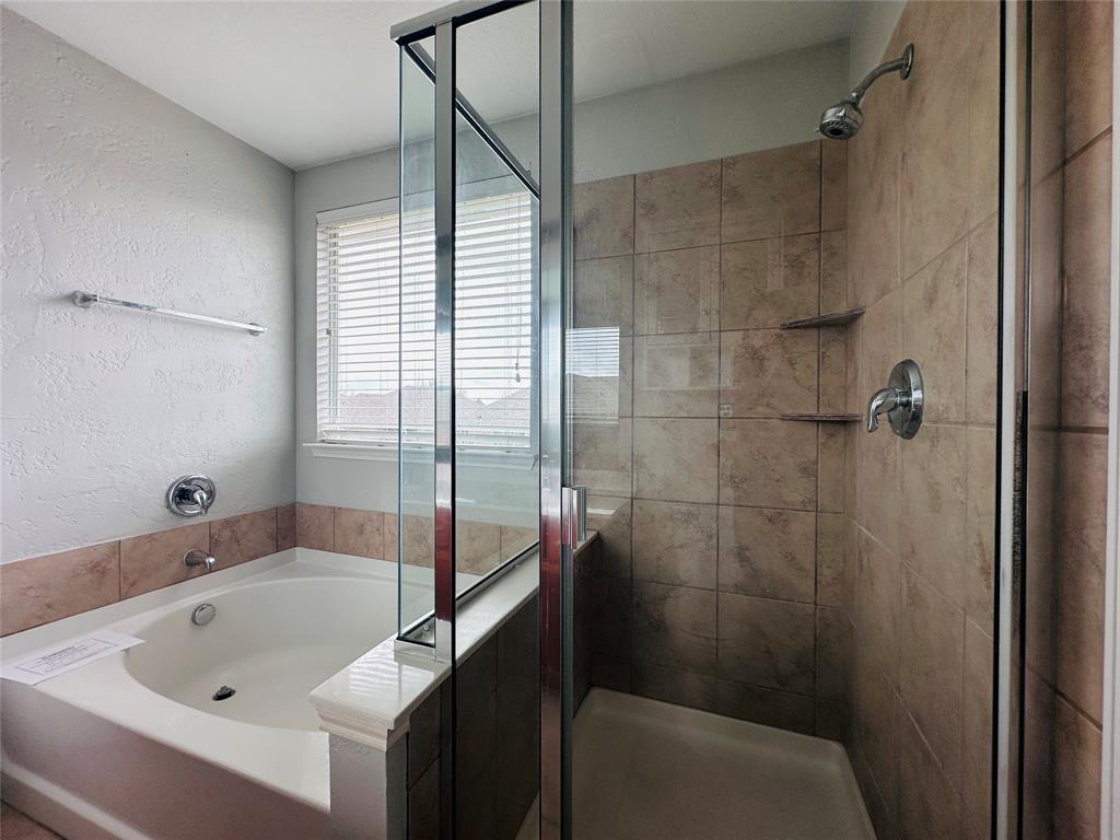 213 Spruce Trail Forney, TX 75126 - Photo 13 of 19 a bathroom with a tub and shower