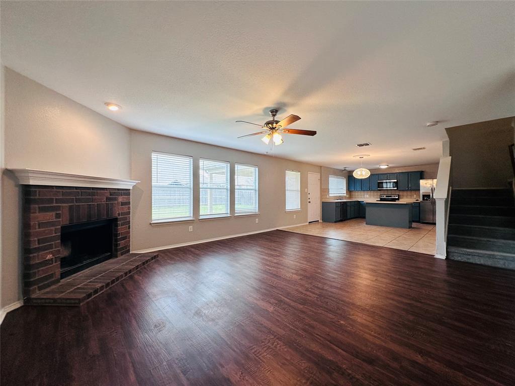 213 Spruce Trail Forney, TX 75126 - Photo 2 of 19 a view of an empty room with wooden floor fireplace and a window