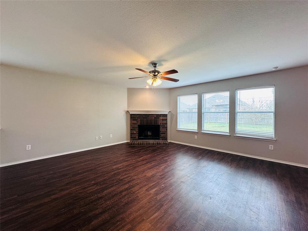 213 Spruce Trail Forney, TX 75126 - Photo 3 of 19 a view of an empty room with wooden floor and a window