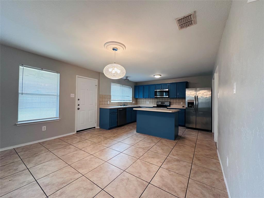 213 Spruce Trail Forney, TX 75126 - Photo 6 of 19 a large kitchen with a large counter top and stainless steel appliances