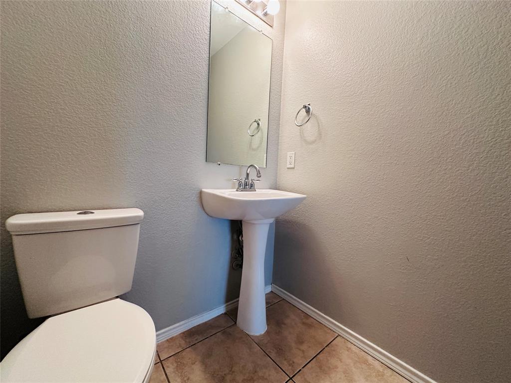 213 Spruce Trail Forney, TX 75126 - Photo 8 of 19 a bathroom with a toilet sink and mirror
