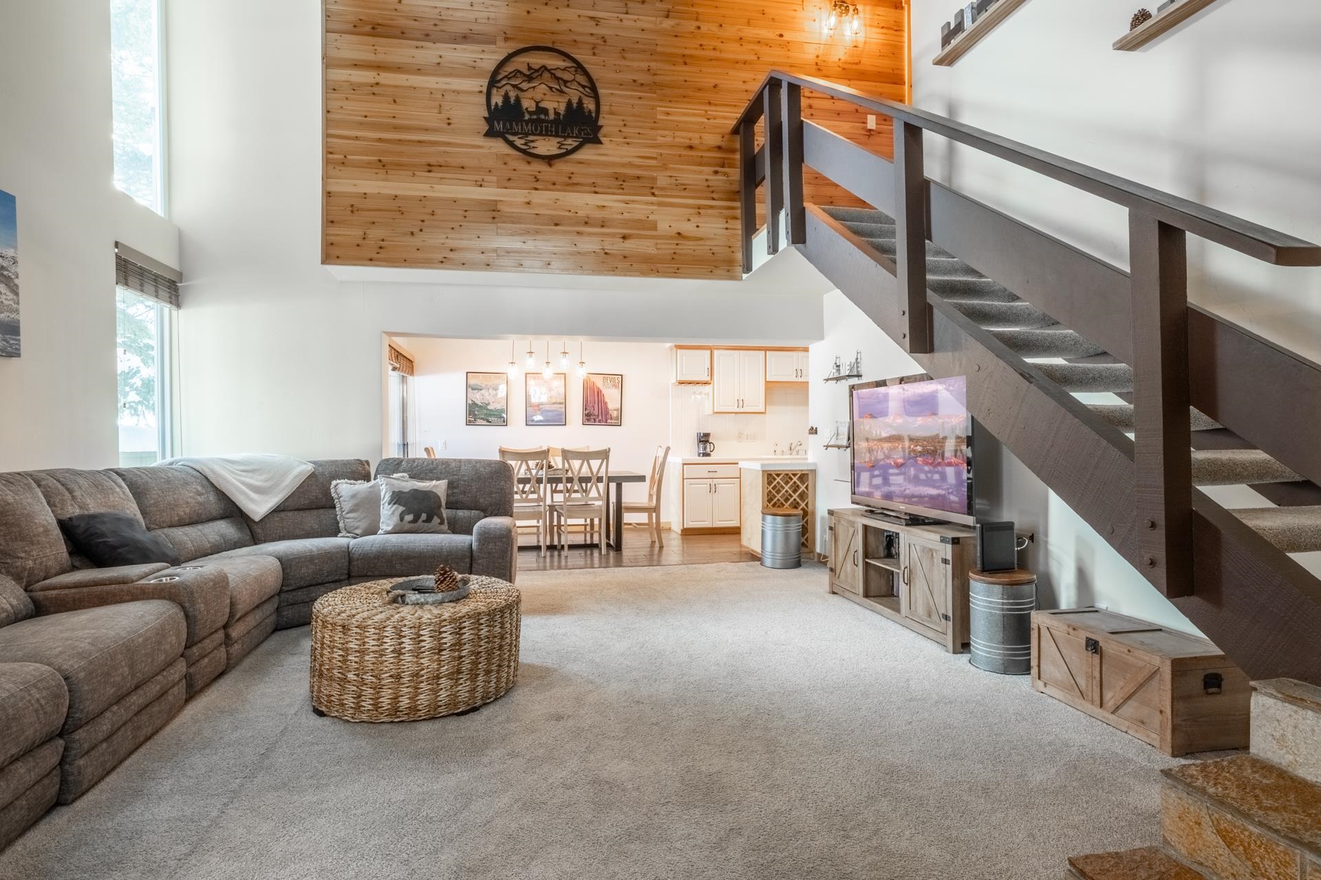 Living area with a high ceiling and light colored carpet