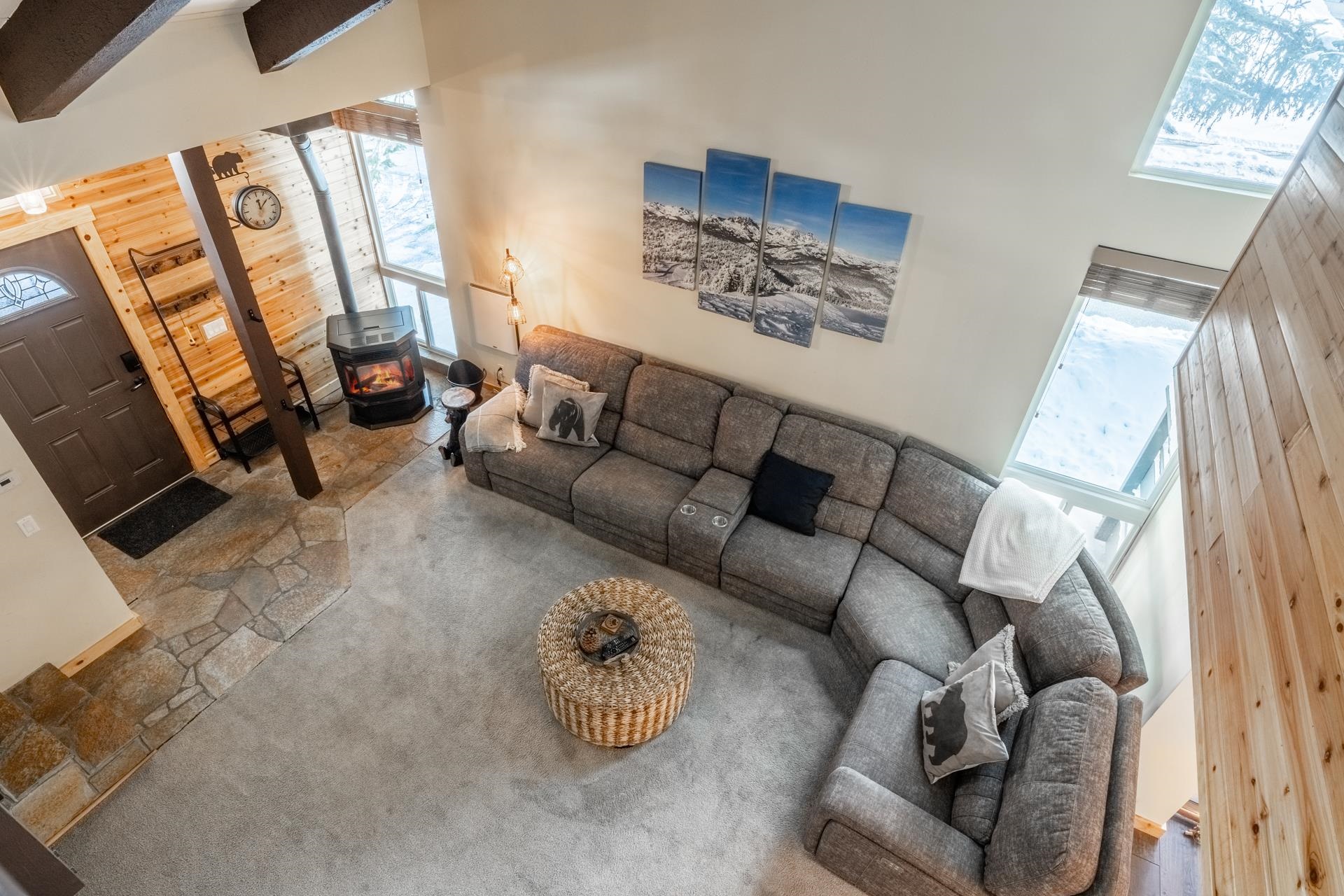 150 Sierra Park Road, Unit 6 Mammoth Lakes, CA 93546 - Photo 13 of 31 Carpeted living room with a high ceiling, a wood stove, wood walls, and stone finish flooring
