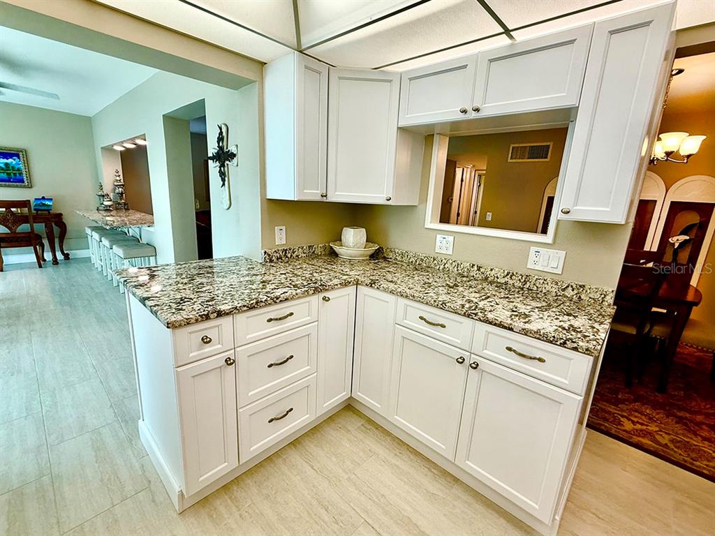 4455 Duhme Road, Unit 103 St. Petersburg, FL 33708 - Photo 9 of 37 a kitchen with granite countertop a sink stove and refrigerator