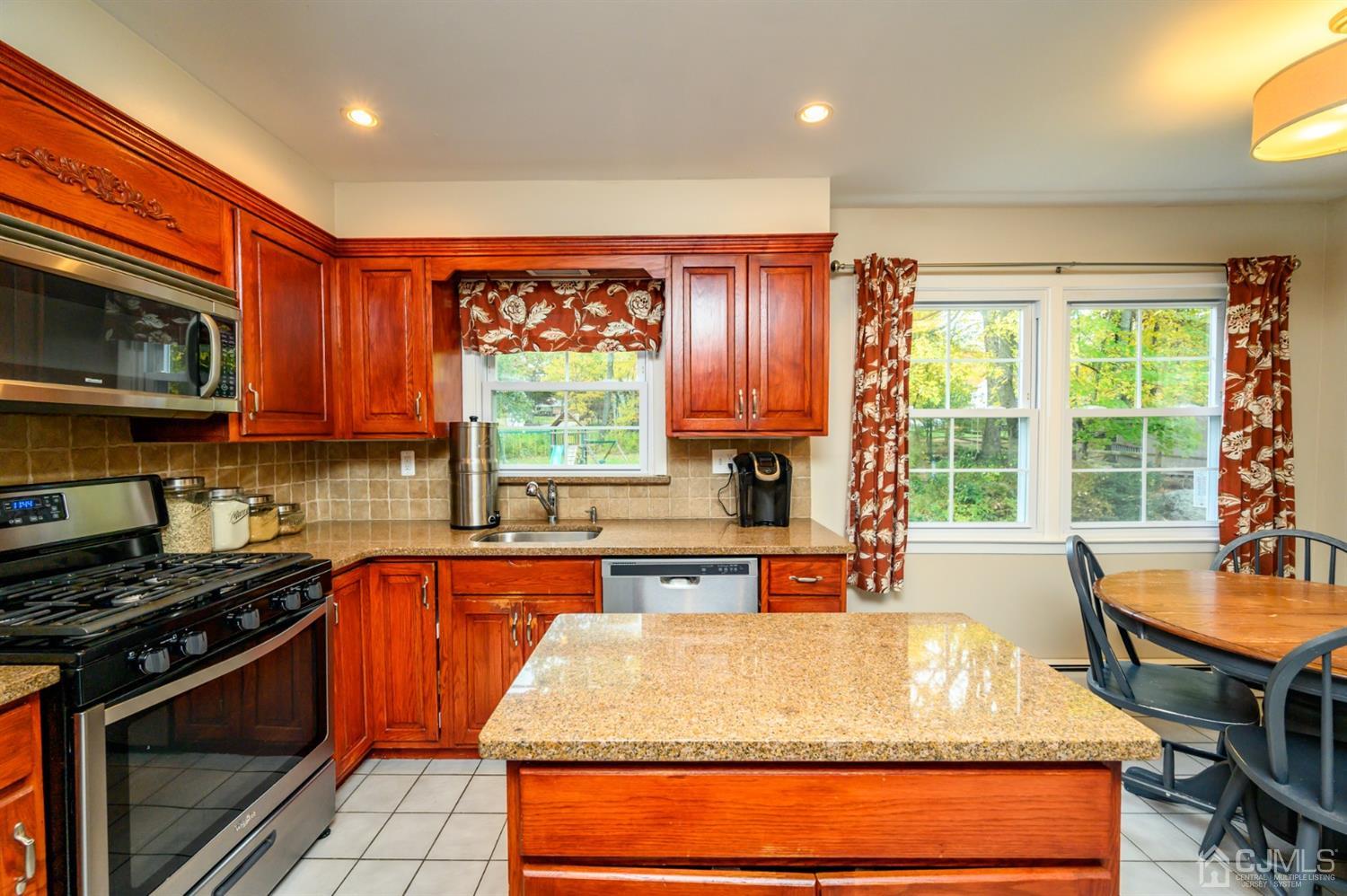24 Clover Lane Randolph, NJ 07869 - Photo 13 of 59 a kitchen with a stove a sink a microwave and wooden cabinets