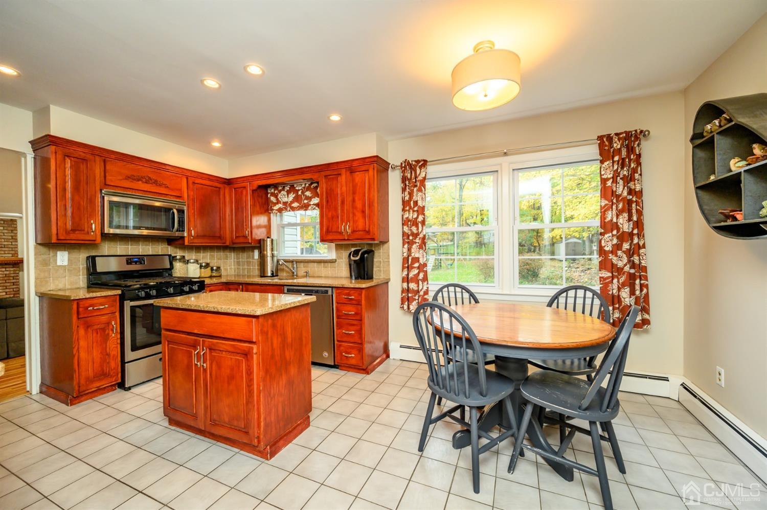 24 Clover Lane Randolph, NJ 07869 - Photo 14 of 59 a kitchen with stainless steel appliances granite countertop a stove a sink a refrigerator a microwave oven with a dining table and chairs