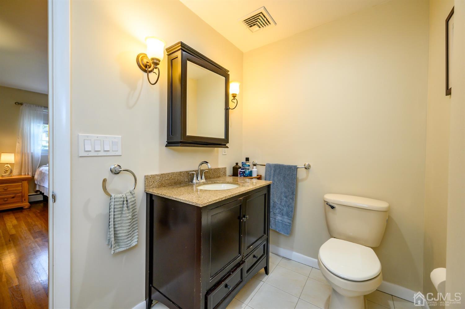 24 Clover Lane Randolph, NJ 07869 - Photo 28 of 59 a bathroom with a toilet sink vanity and mirror