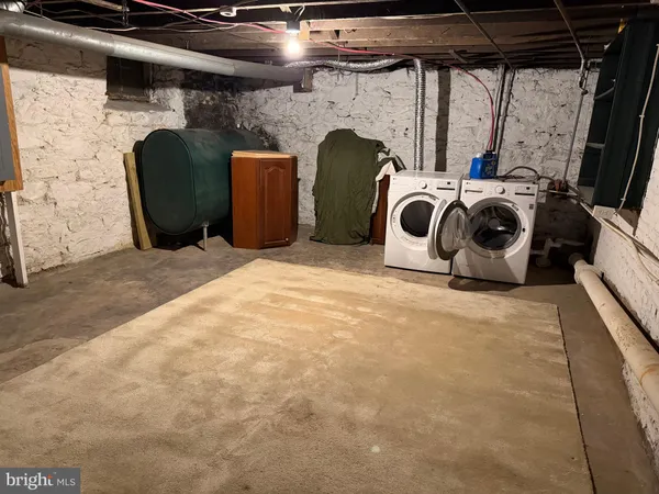 a room with a washing machine and a chair
