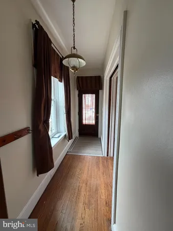 a view of hallway with stairs and wooden floor