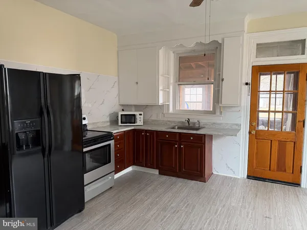 a kitchen with granite countertop wooden floors and stainless steel appliances