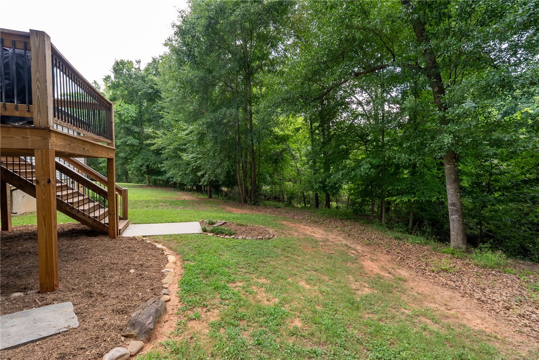 201 Hearthstone Drive Anderson, SC 29621 - Photo 46 of 49 A spacious wooden deck provides elevated outdoor living, overlooking a verdant landscape with mature trees.