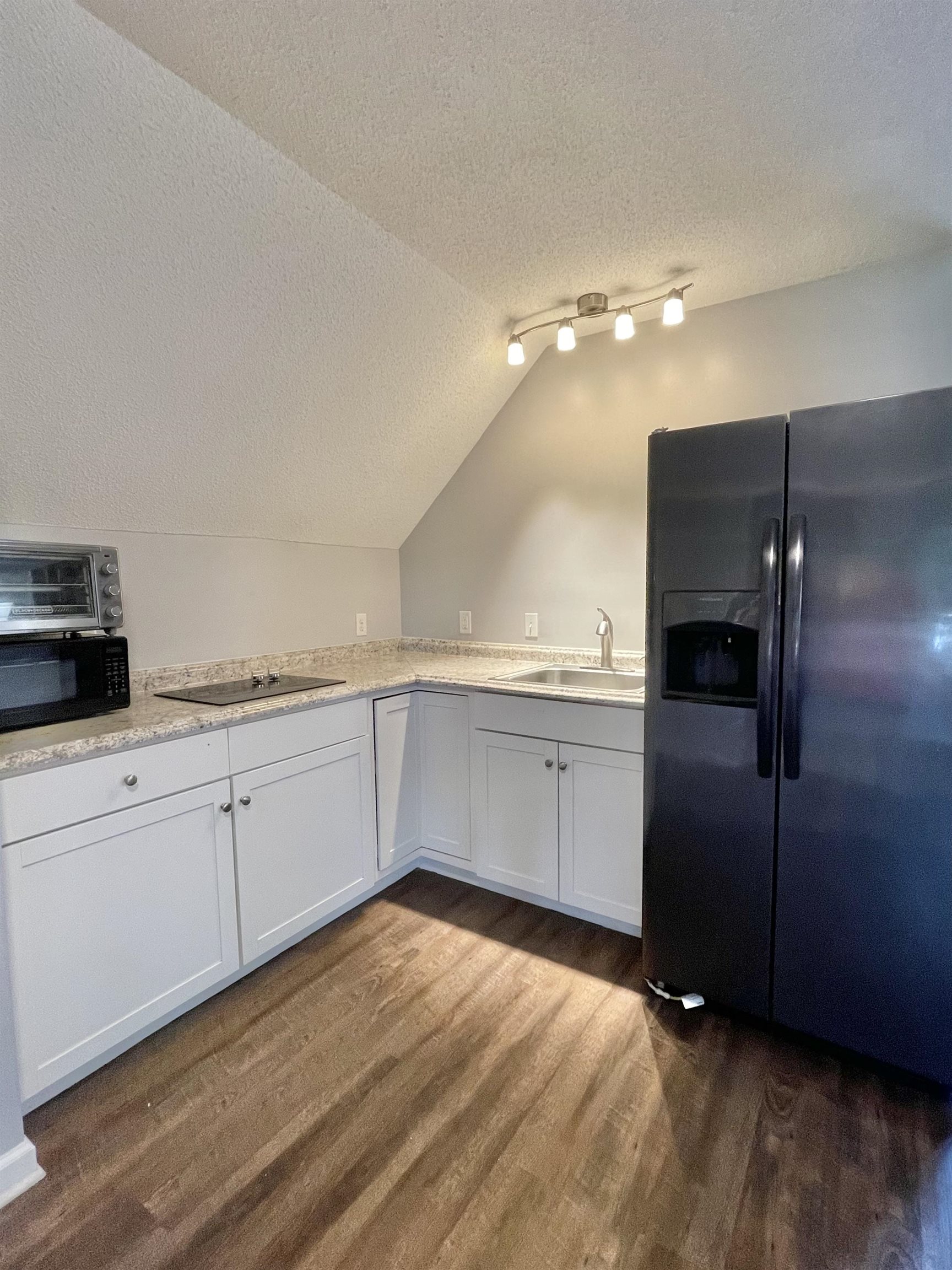 3446 Peter Cove Bartlett, TN 38133 - Photo 2 of 6 a kitchen with a refrigerator and white cabinets