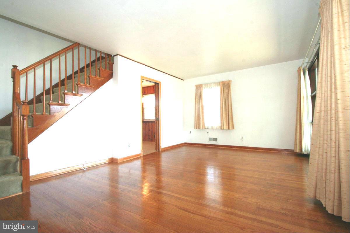 1604 Lynch Road Dundalk, MD 21222 - Photo 1 of 30 a view of an empty room with wooden floor and a window
