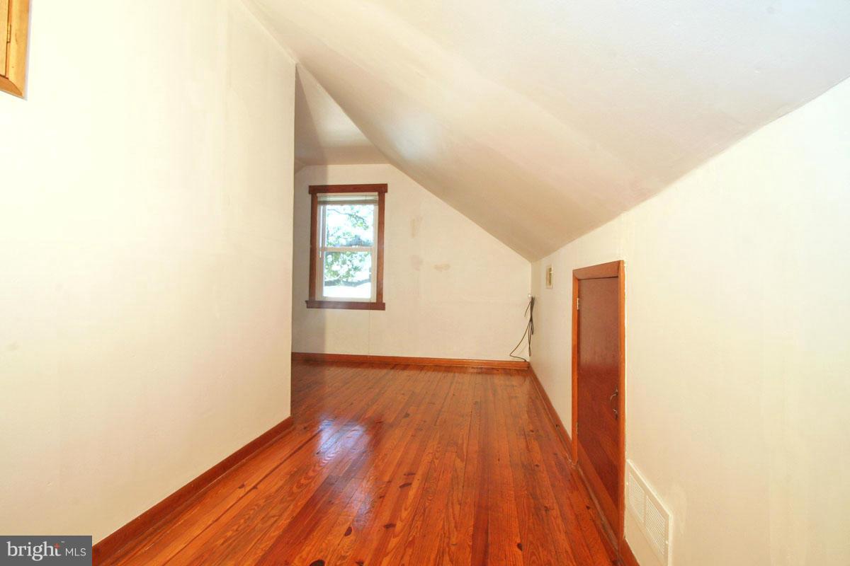 1604 Lynch Road Dundalk, MD 21222 - Photo 14 of 30 a view of an empty room with wooden floor and a window