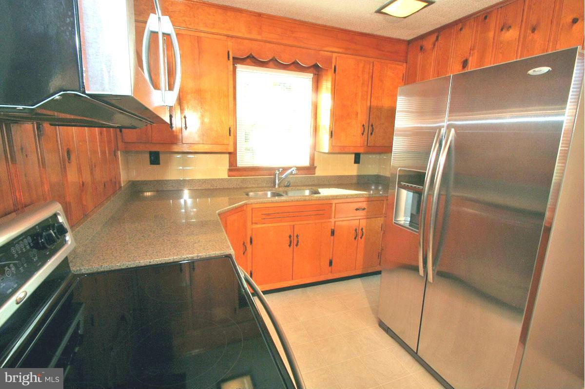 1604 Lynch Road Dundalk, MD 21222 - Photo 3 of 30 a kitchen with stainless steel appliances granite countertop a refrigerator a stove and a sink with wooden floor