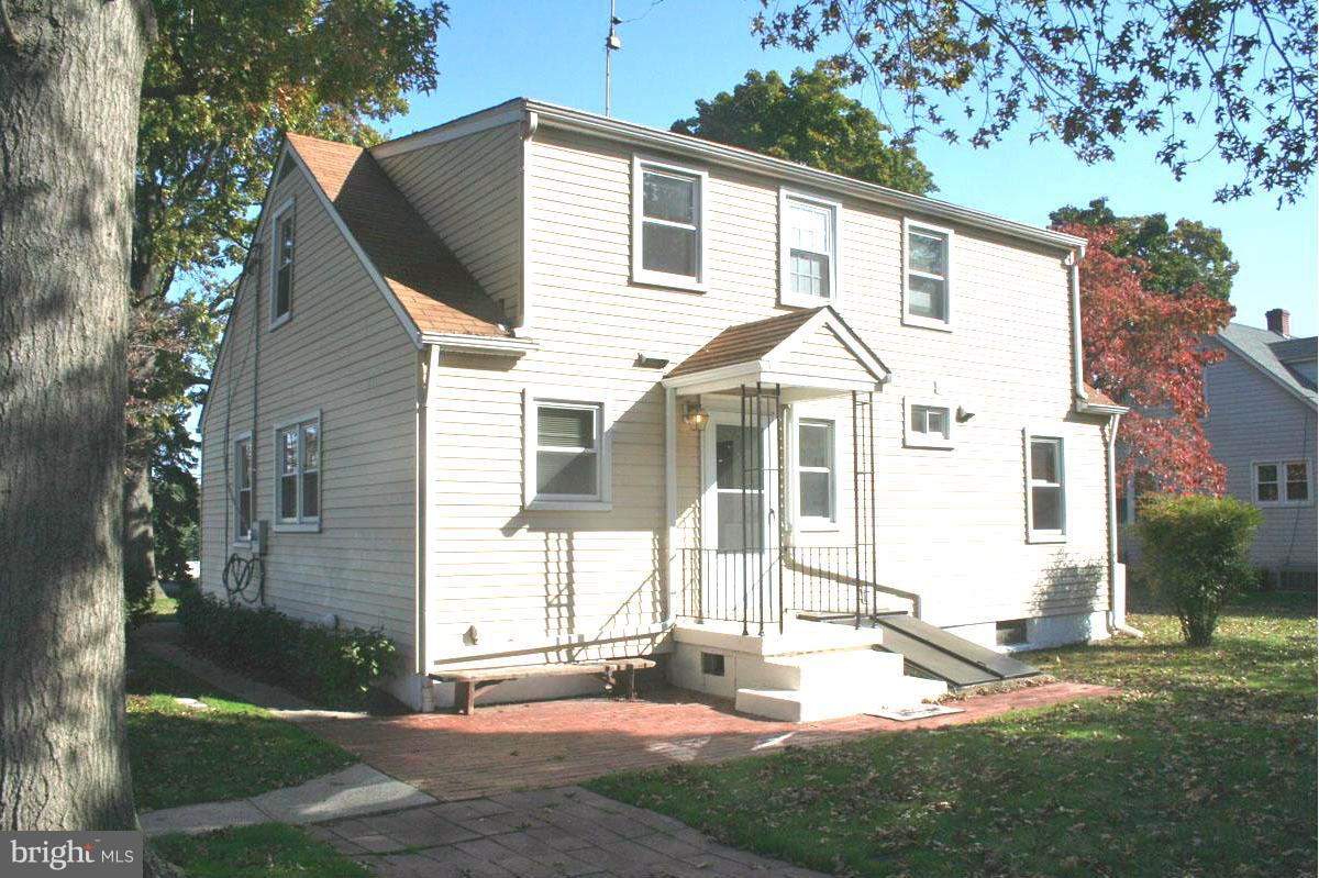 1604 Lynch Road Dundalk, MD 21222 - Photo 22 of 30 a view of a white house with a yard and table and chairs under an umbrella