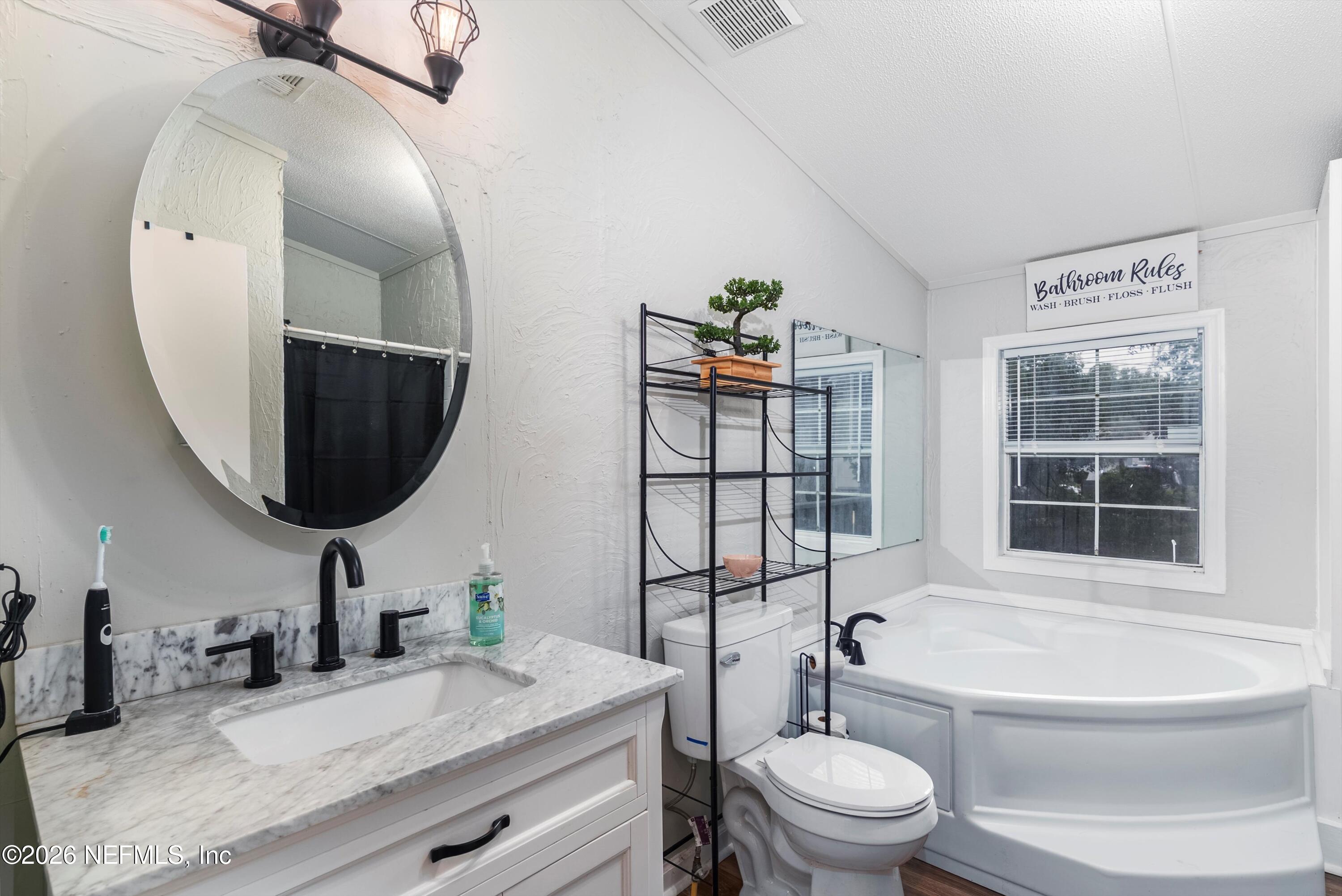 85246 Johnson Lane Yulee, FL 32097 - Photo 18 of 46 a bathroom with a toilet a sink and a mirror