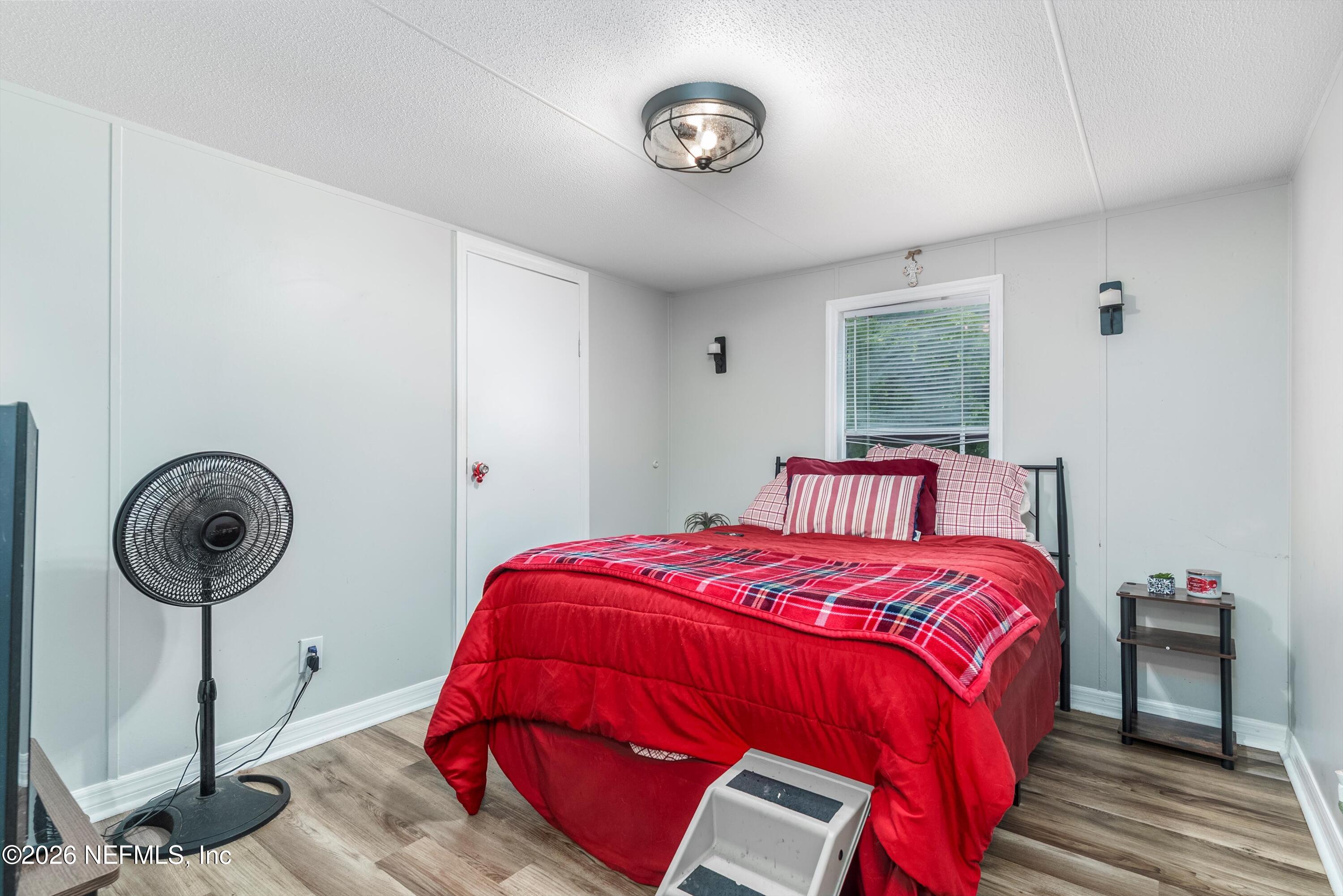 85246 Johnson Lane Yulee, FL 32097 - Photo 20 of 46 a bedroom with a bed and a chandelier