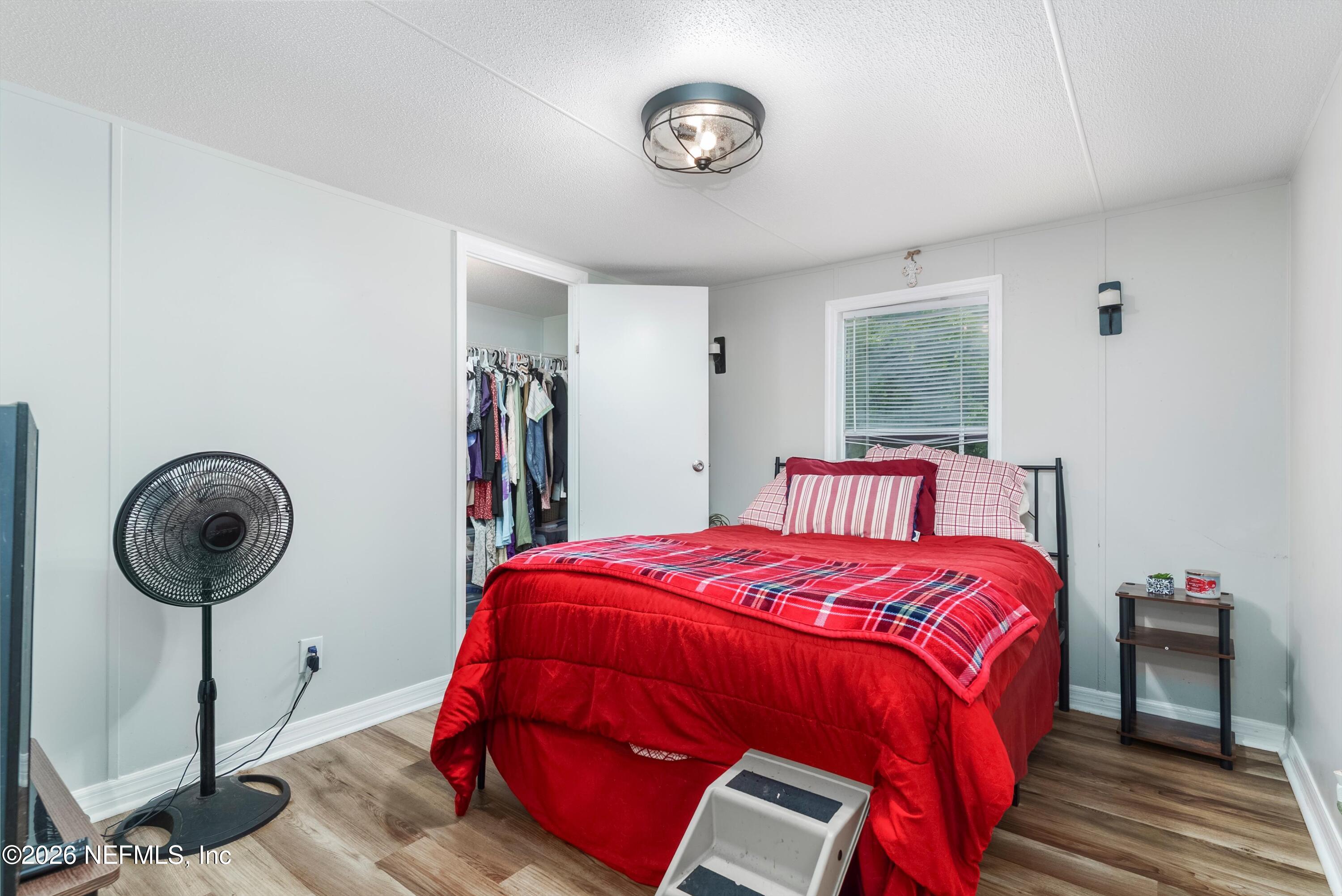 85246 Johnson Lane Yulee, FL 32097 - Photo 21 of 46 a bedroom with a bed and a chandelier